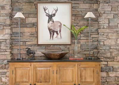 rock wall with dining room sideboard of Moonlight residence designed by Elizabeth Robb Interiors