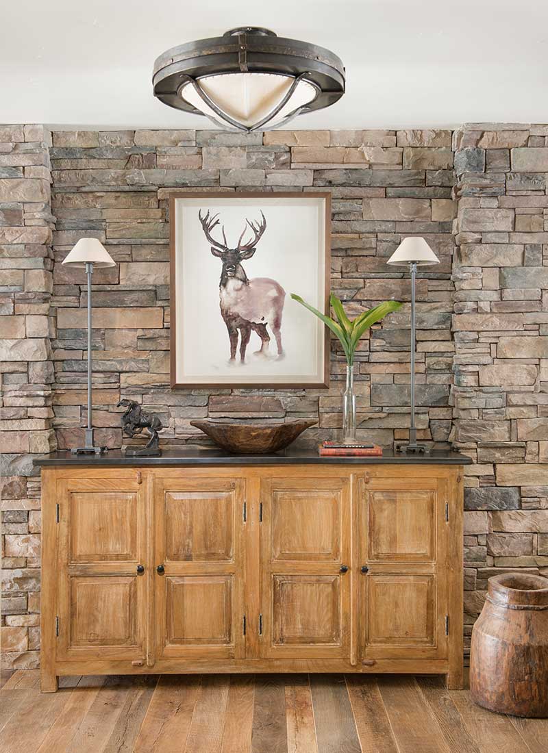 rock wall with dining room sideboard of Moonlight residence designed by Elizabeth Robb Interiors